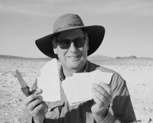 Matt James holing up a fossil fish and smiling