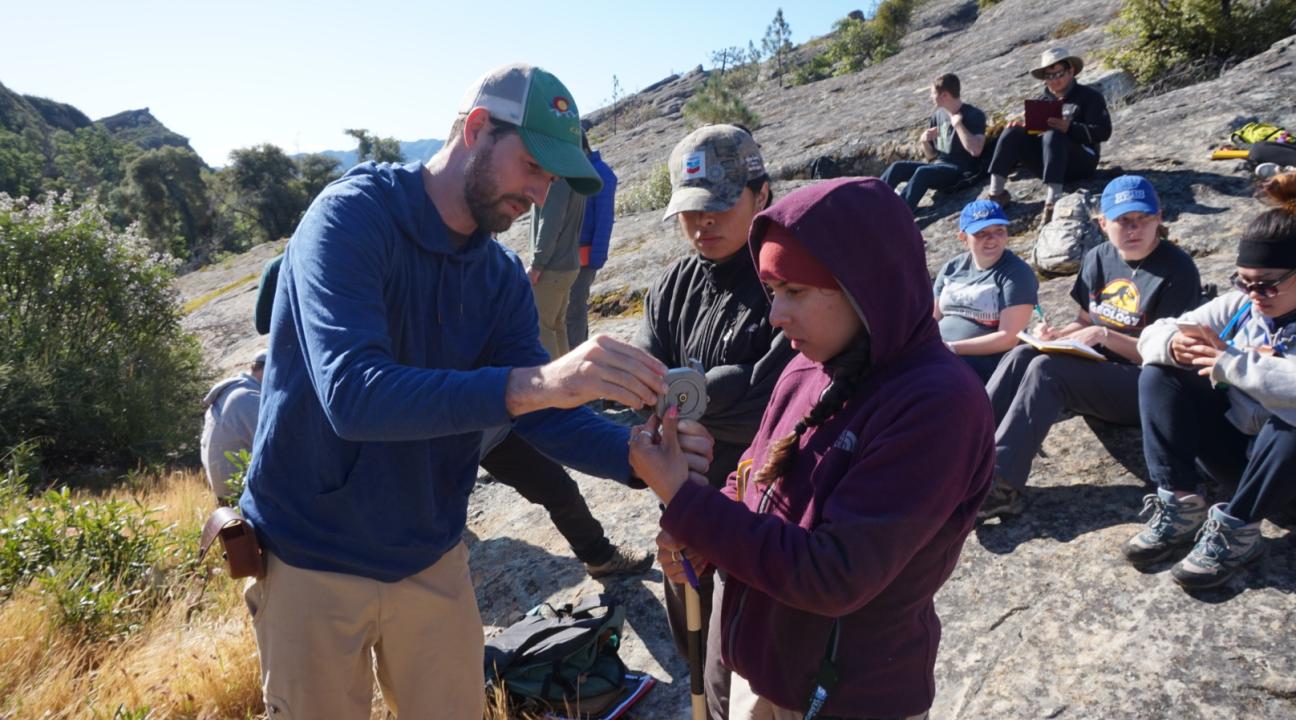 Students learning to use a Jacob's staff