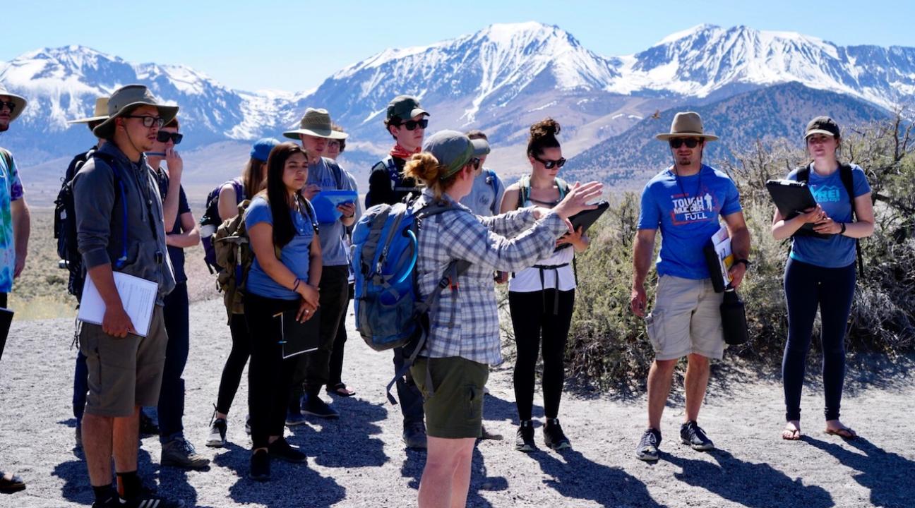 Faculty pointing to the mountains