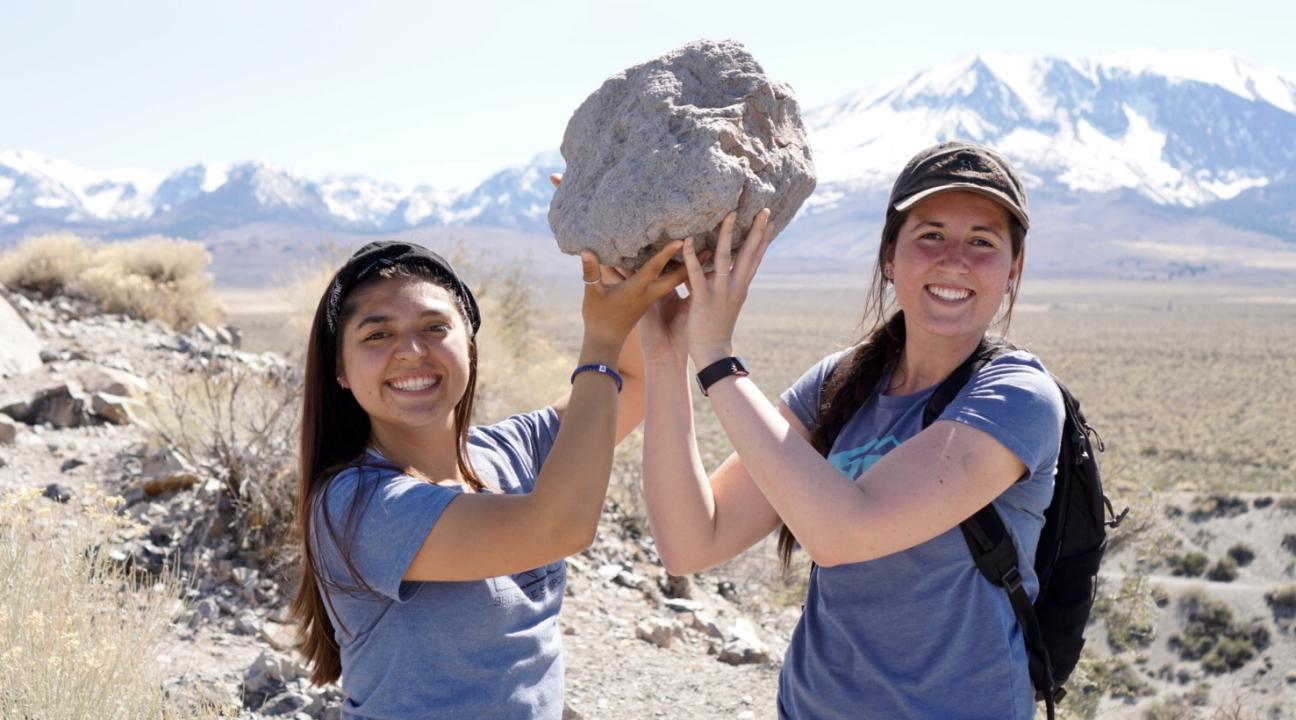 Women lifting big block of pumice