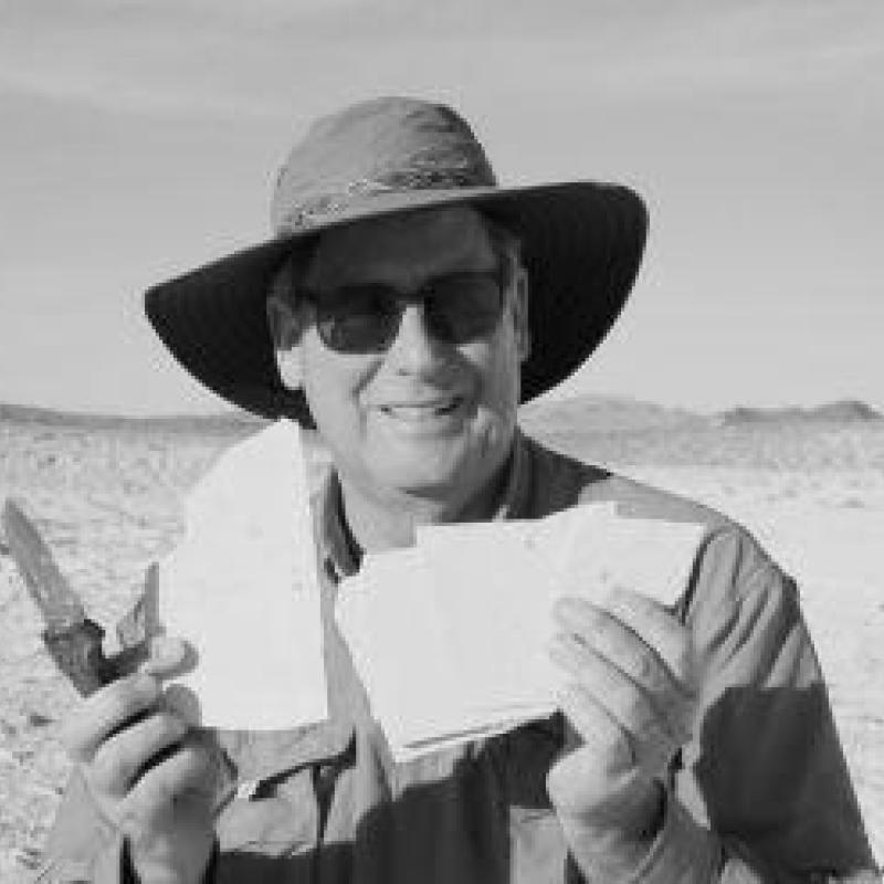 Matt James holing up a fossil fish and smiling