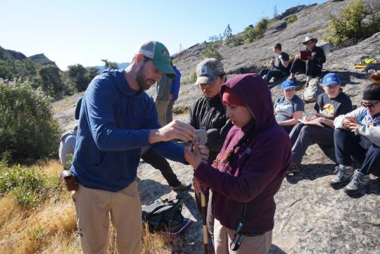 Students learning to use a Jacob's staff